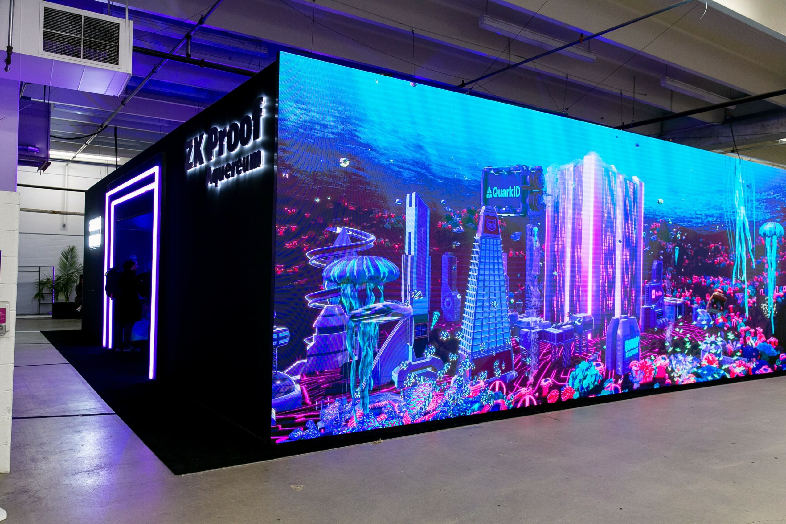 Large digital display showing a colorful cityscape with futuristic buildings and bright lights.