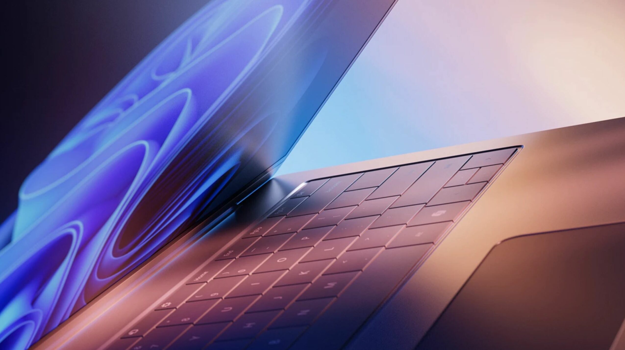 Close-up of a laptop with a glowing screen and keyboard, showing a sleek design.