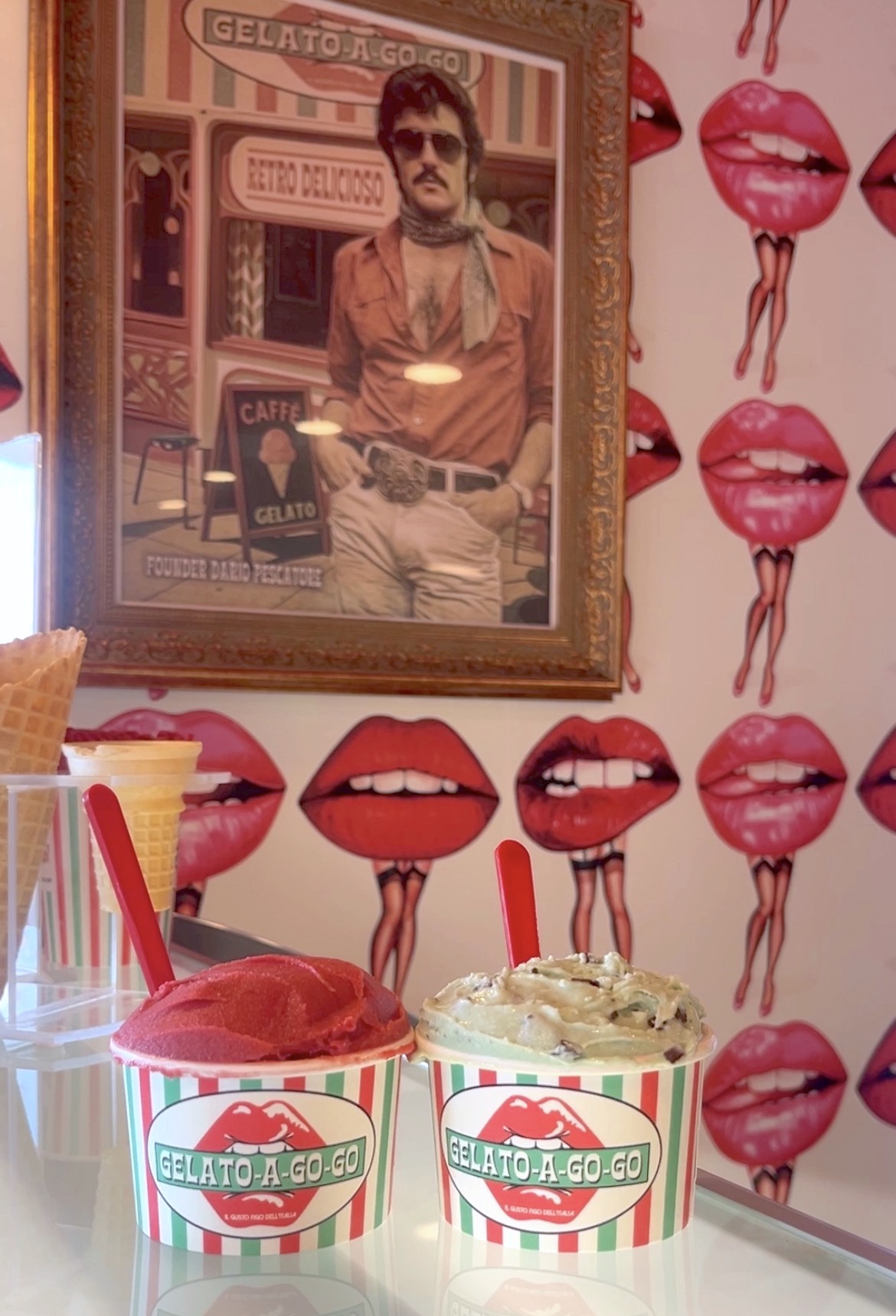 Framed poster of a man with sunglasses in front of a gelato shop, pink lips with dripping ice cream pattern on wall
