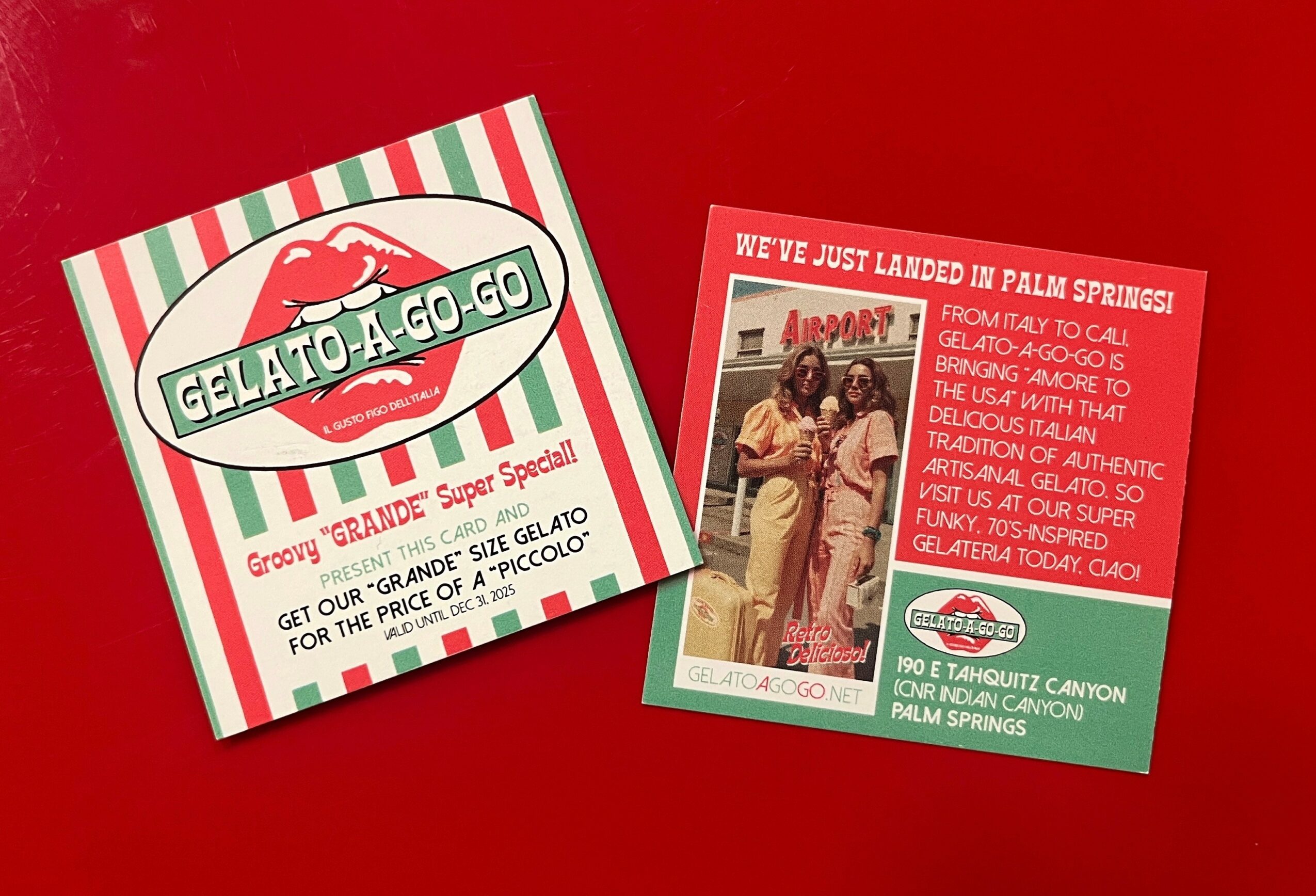 Two flyers for Gelato-A-Go-Go, one with striped green and red background and another with a red background, both on a red surface.