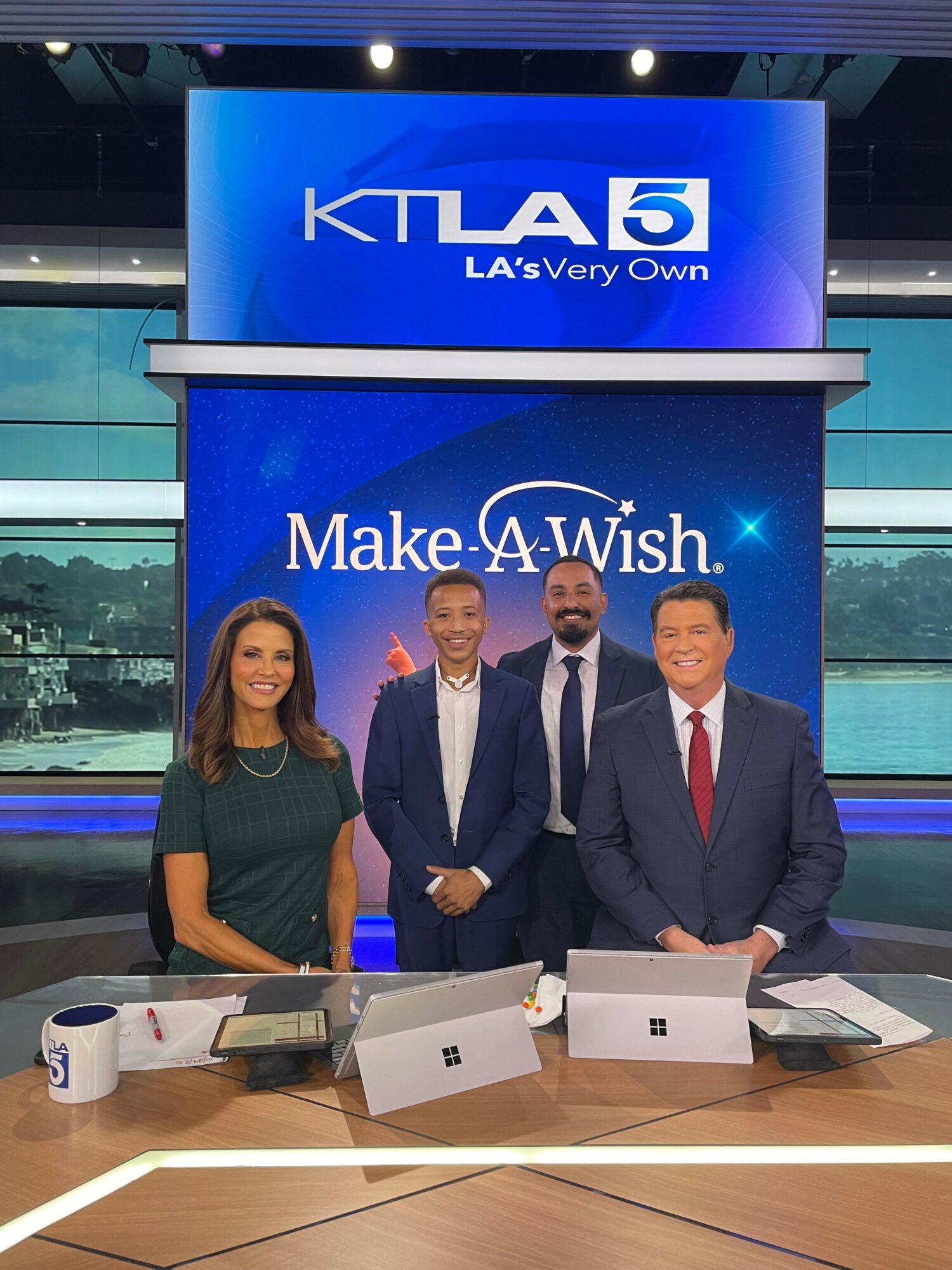 Four people in business attire sit at a table with laptops, in a studio with a KTLA5 banner and a city view.