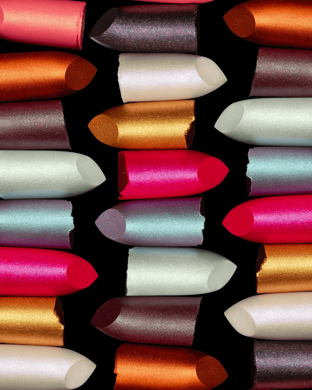 Colorful lipstick tubes arranged vertically, showing various shades including pink, white, orange, and gray.