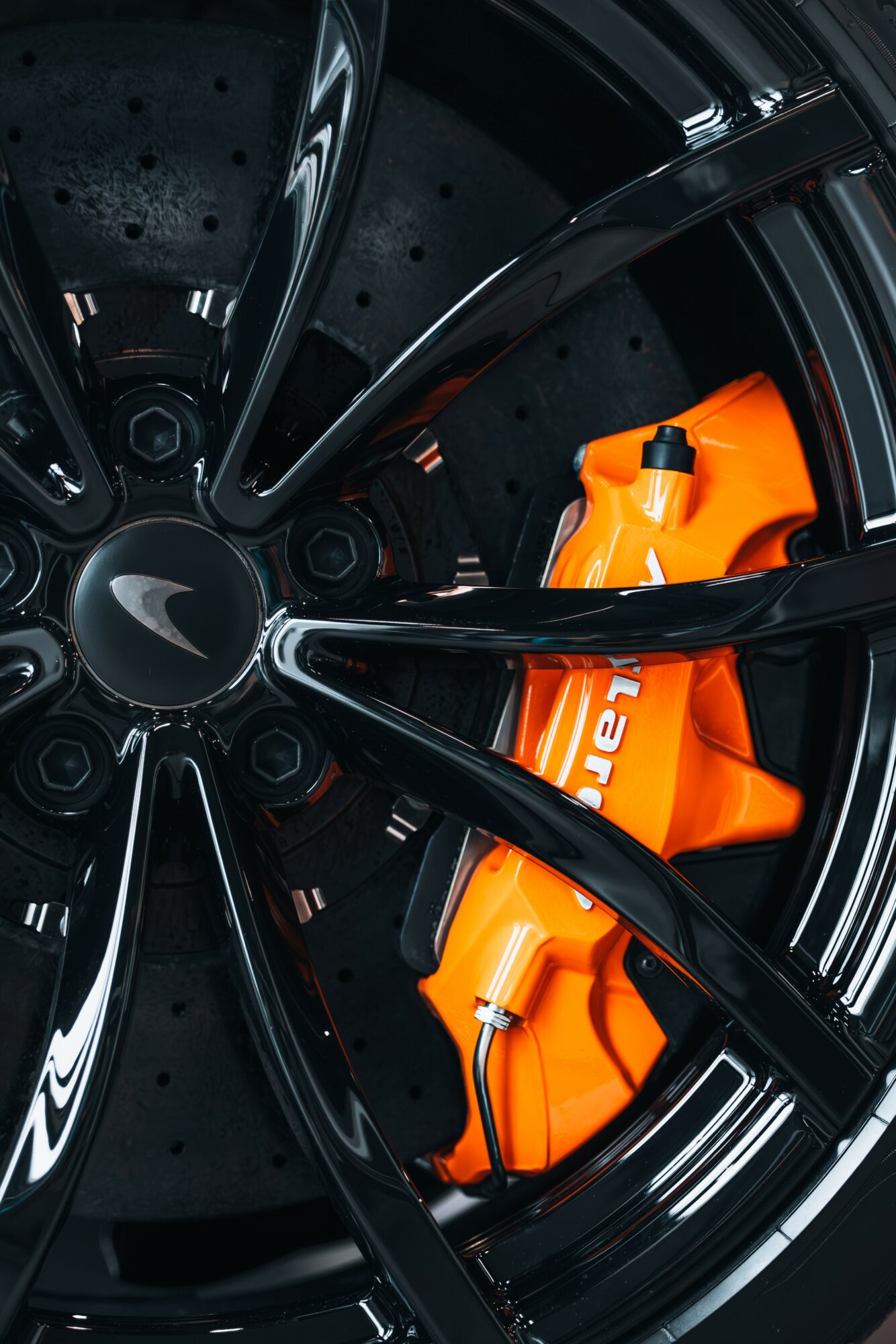 Close-up of a black car wheel with an orange safety vest inside the rim.