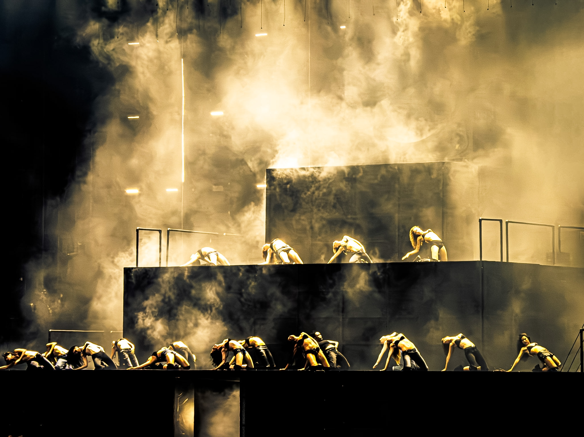 Firefighters in protective gear work on a smoky, elevated platform with smoke billowing around them.