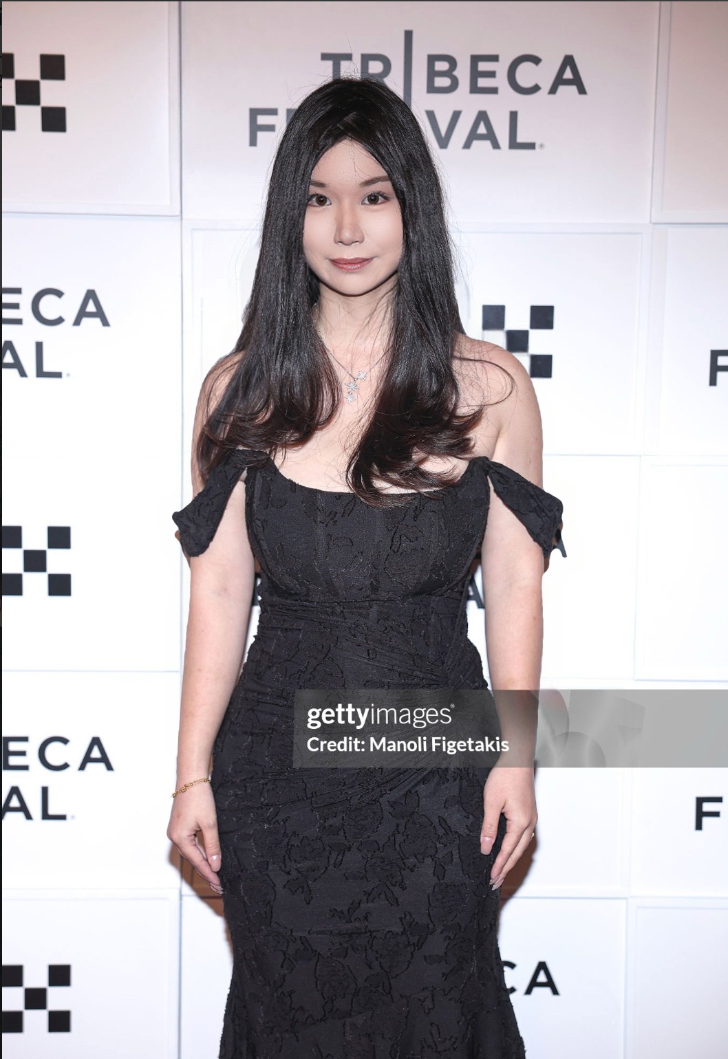 Young woman with long dark hair in a black dress standing in front of a white background with text. Word count: 20