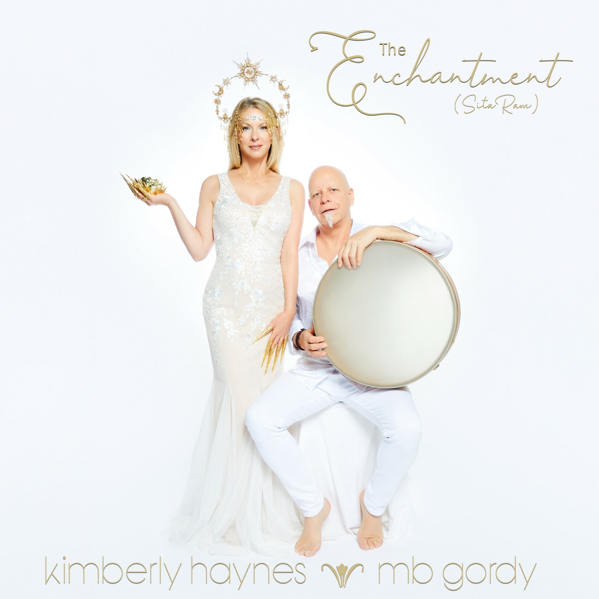 Two women, one standing and one sitting, with a white background. The standing woman wears a white dress, holding a bowl, and the seated woman holds a large drum. Text reads 'The Enchantment (Star Realm)' and names 'kimberly haynes' and 'mb gordy'.