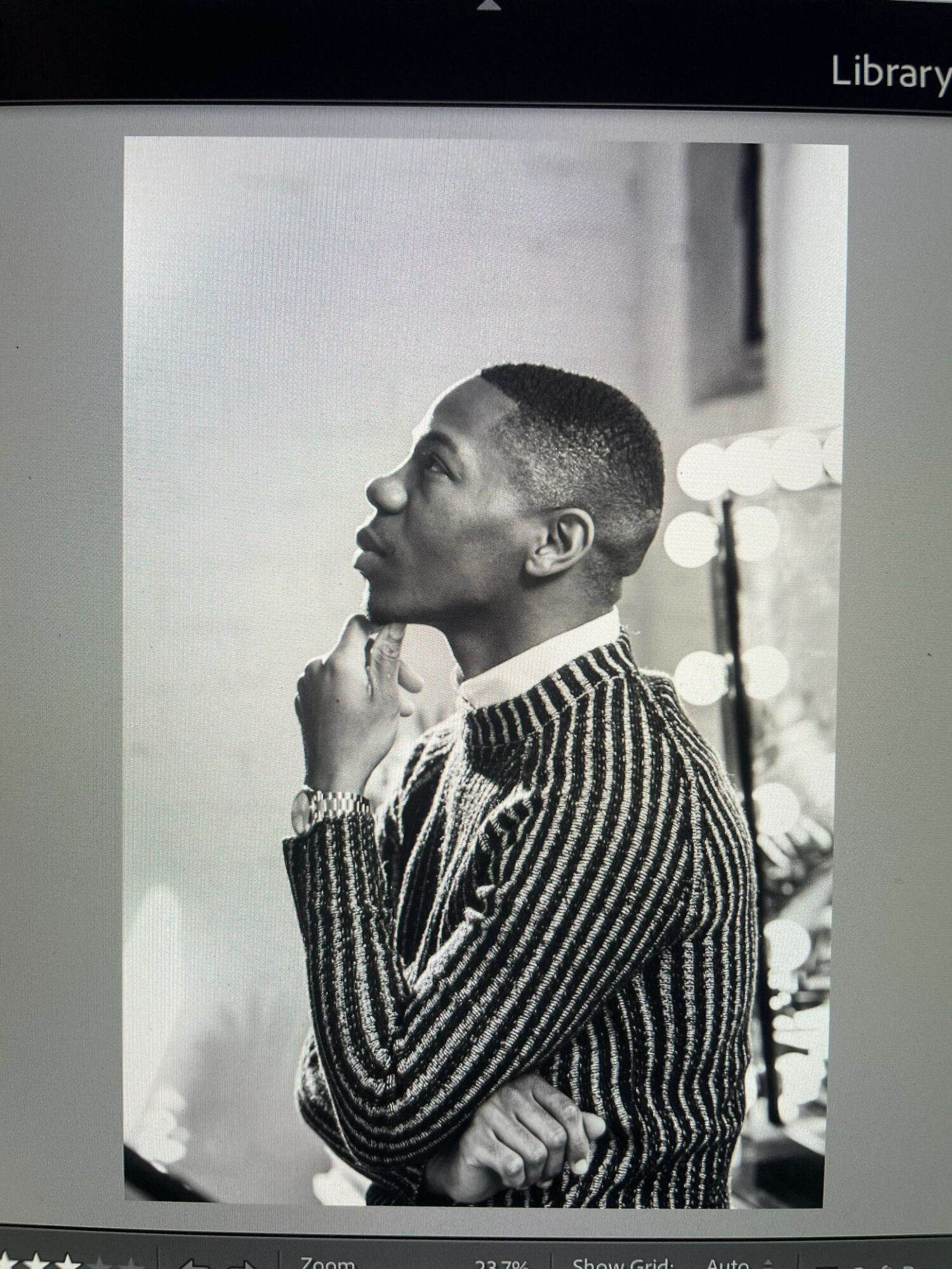 Young man with short hair, wearing a striped sweater, holding a microphone close to his mouth, singing or speaking.