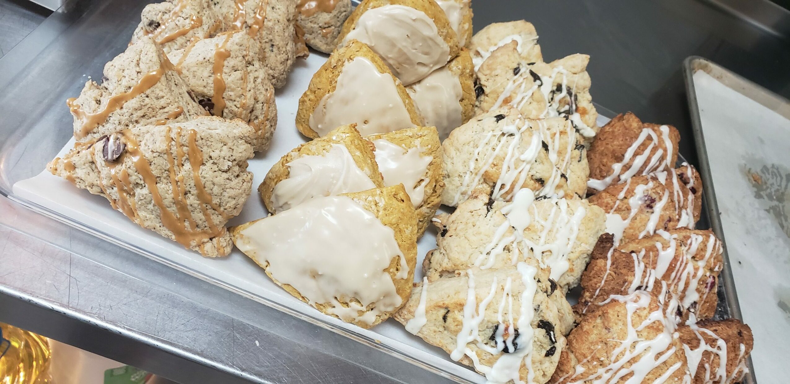 Assorted cookies in a container, some with icing and toppings, viewed from above.