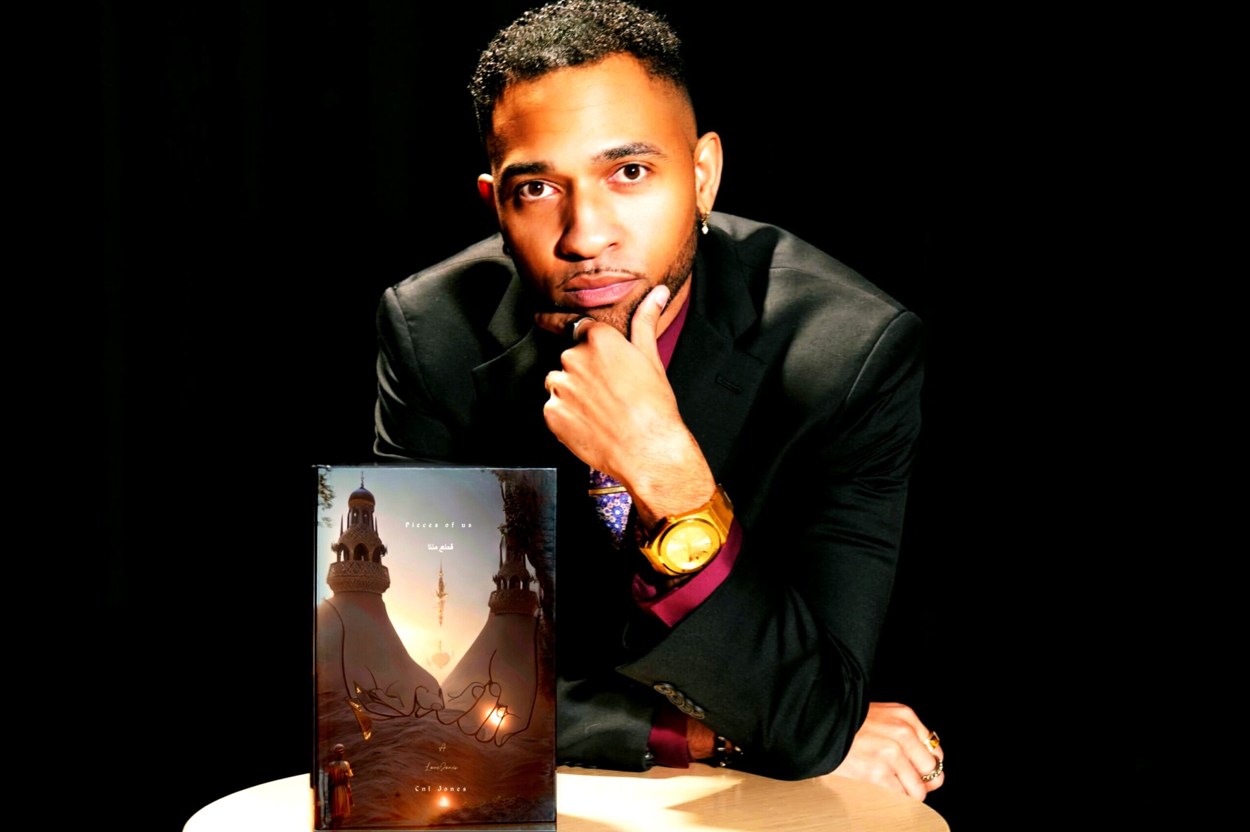 Man in black suit with hand on chin, gold watch, dark background, holding a photo of a monument, 20 words