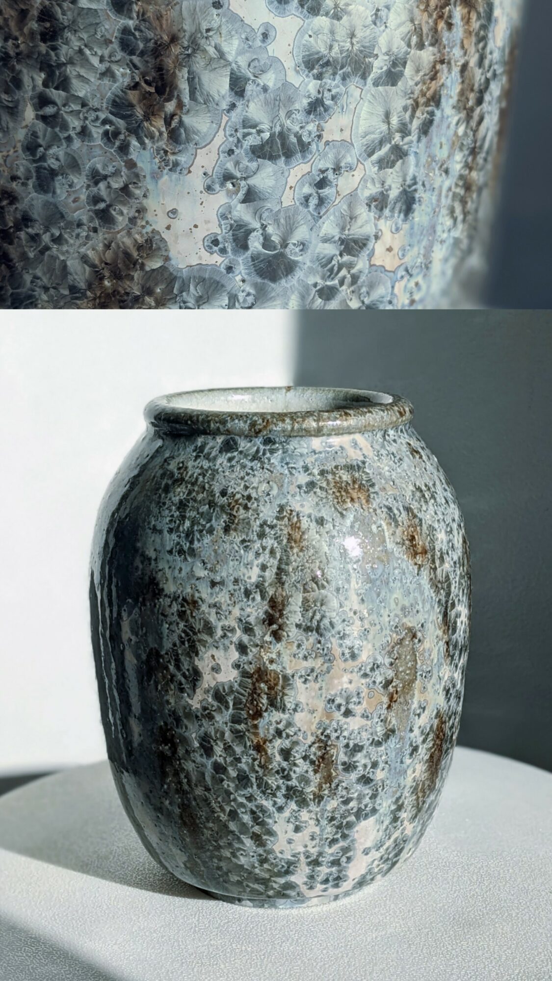 A weathered, rusted metal vase with a rounded shape and wide opening, placed on a surface with a plain background.