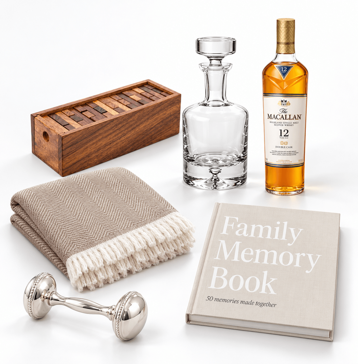 Objects on a white surface include a wooden box, glass decanter, bottle of Macallan 12-year whiskey, beige blanket, silver dumbbell, and family memory book.