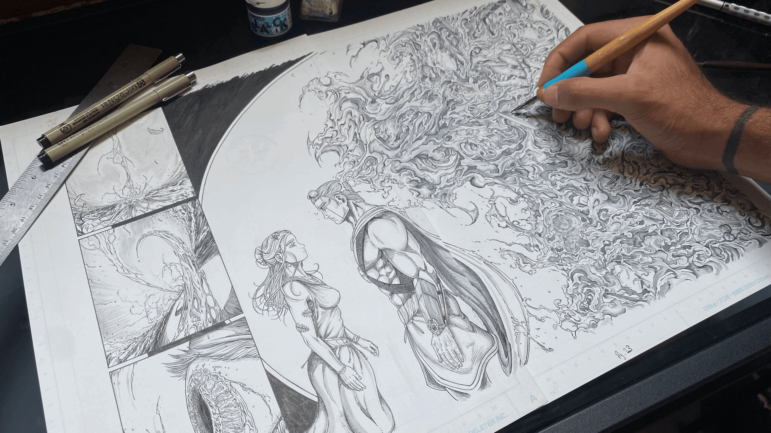 Artist's hand sketching detailed illustrations on a large sheet of paper with pencils and pens nearby.