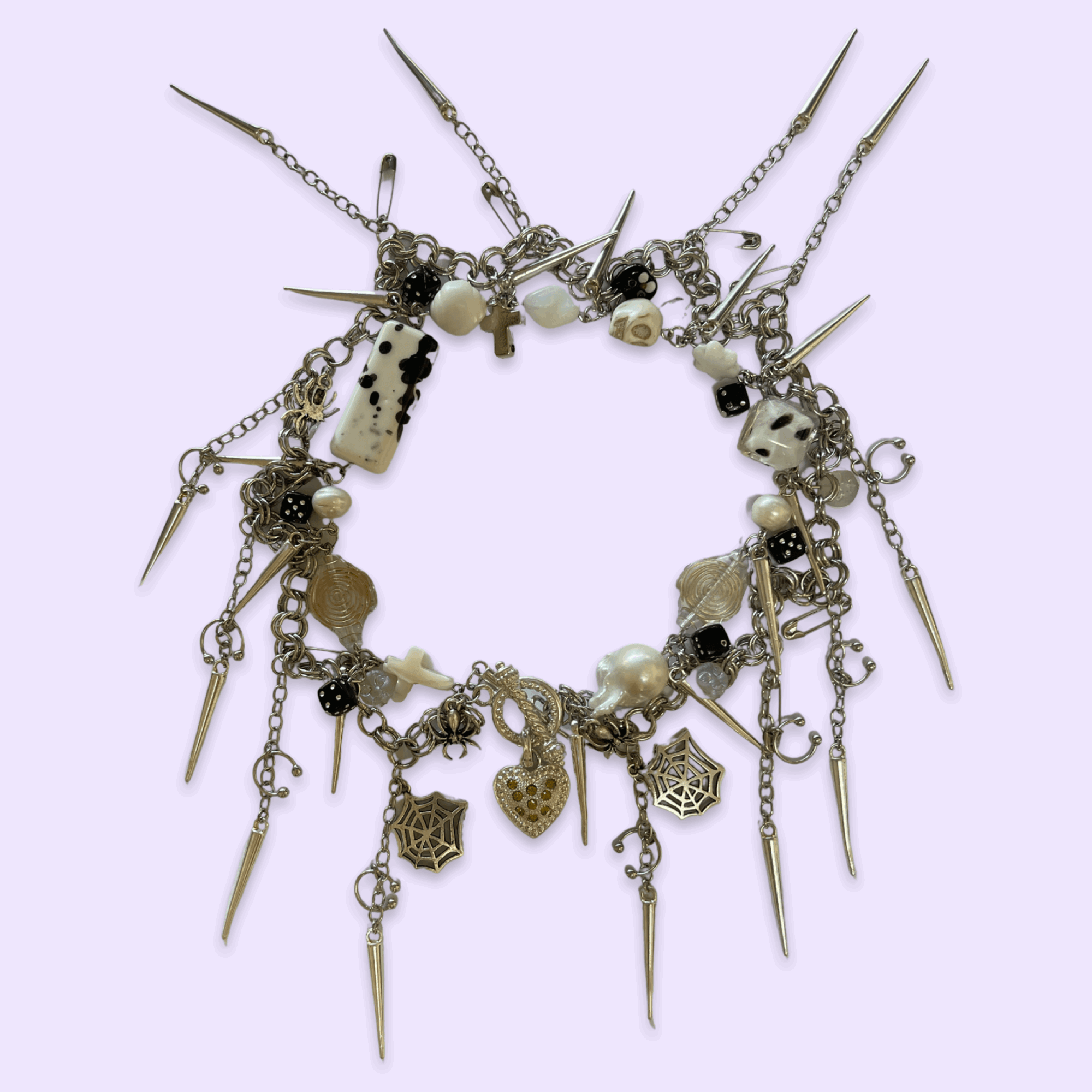 Bracelet with various charms, beads, and spikes on a light purple background.