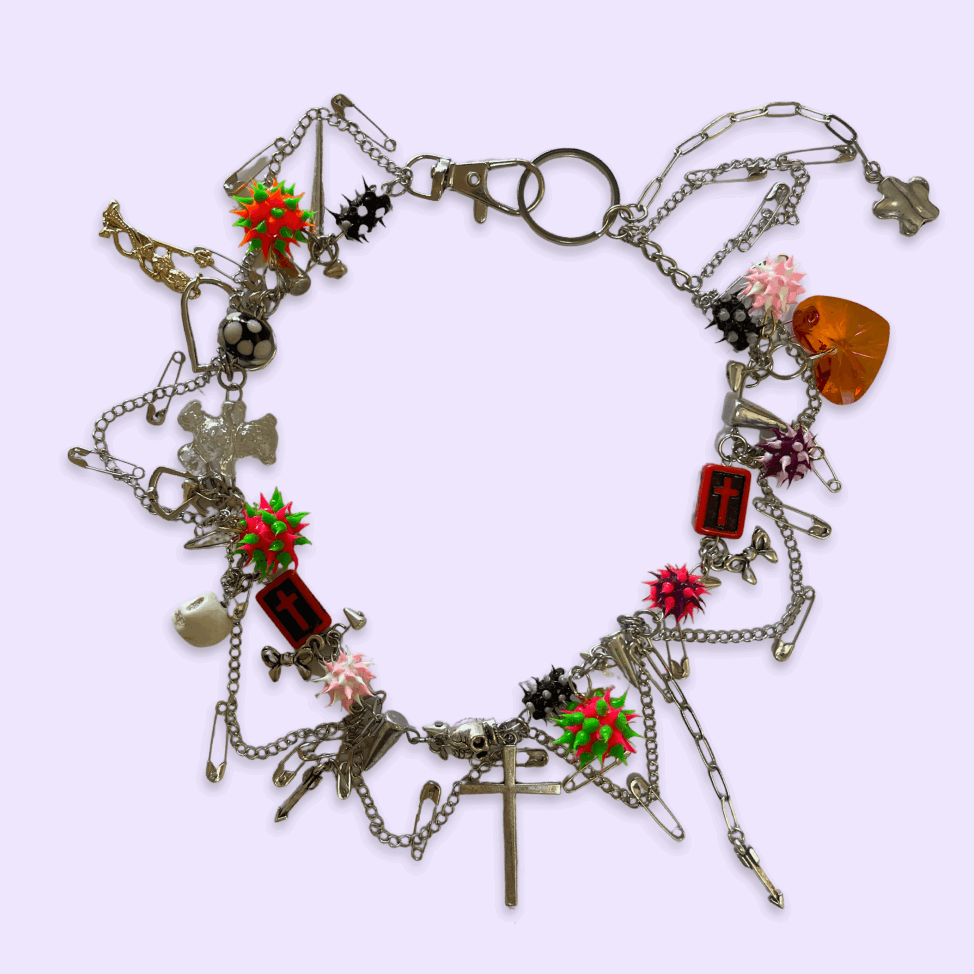 A silver charm bracelet with various charms including flowers, a cross, a heart, and other decorative elements, on a light background.