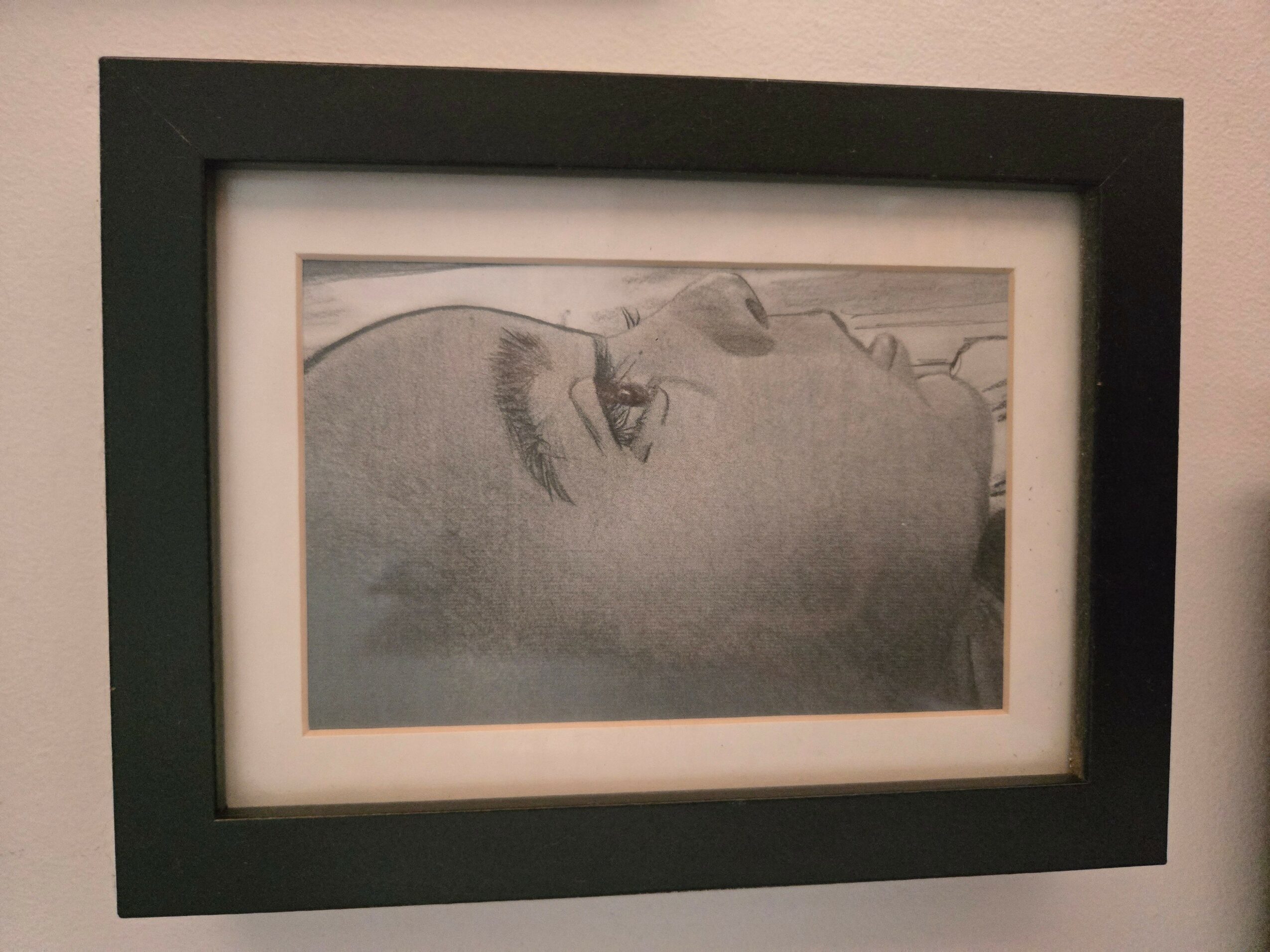 Black and white portrait of a person lying down, viewed from the side, with eyes closed.