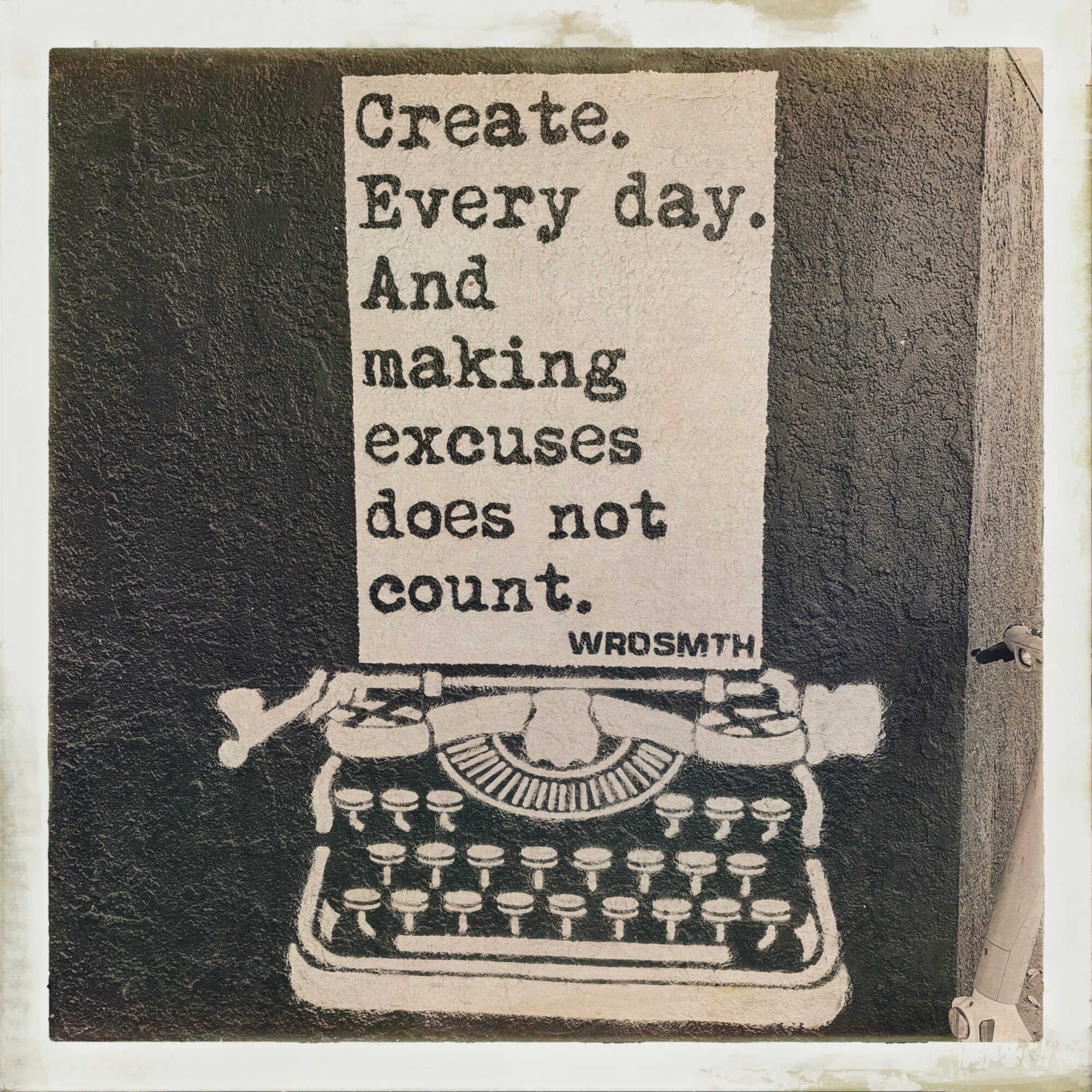 Typewriter with a sign above it reading, 'Create. Every day. And making excuses does not count.'