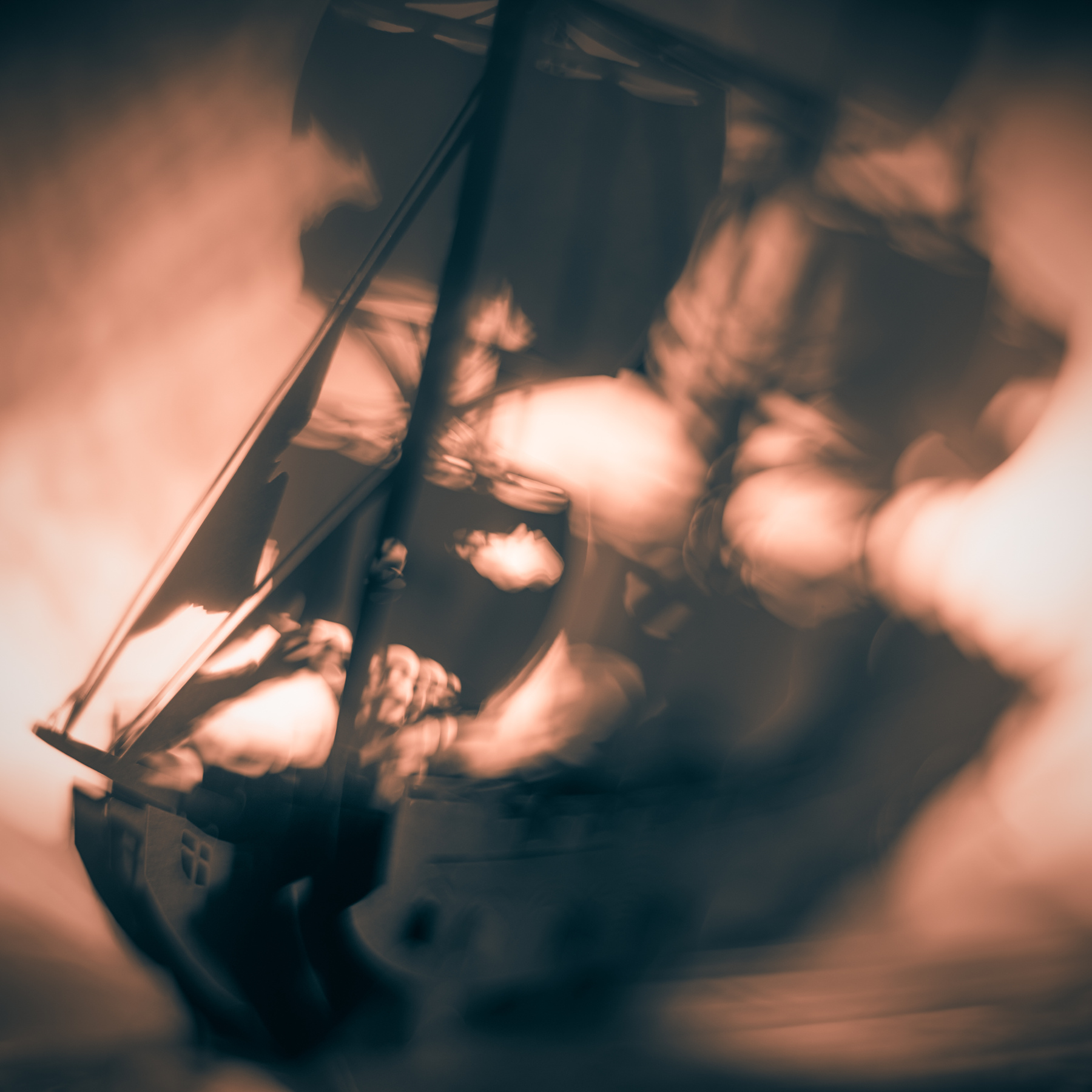 A boat with sails is reflected in water, with clouds in the sky above, viewed at an angle.