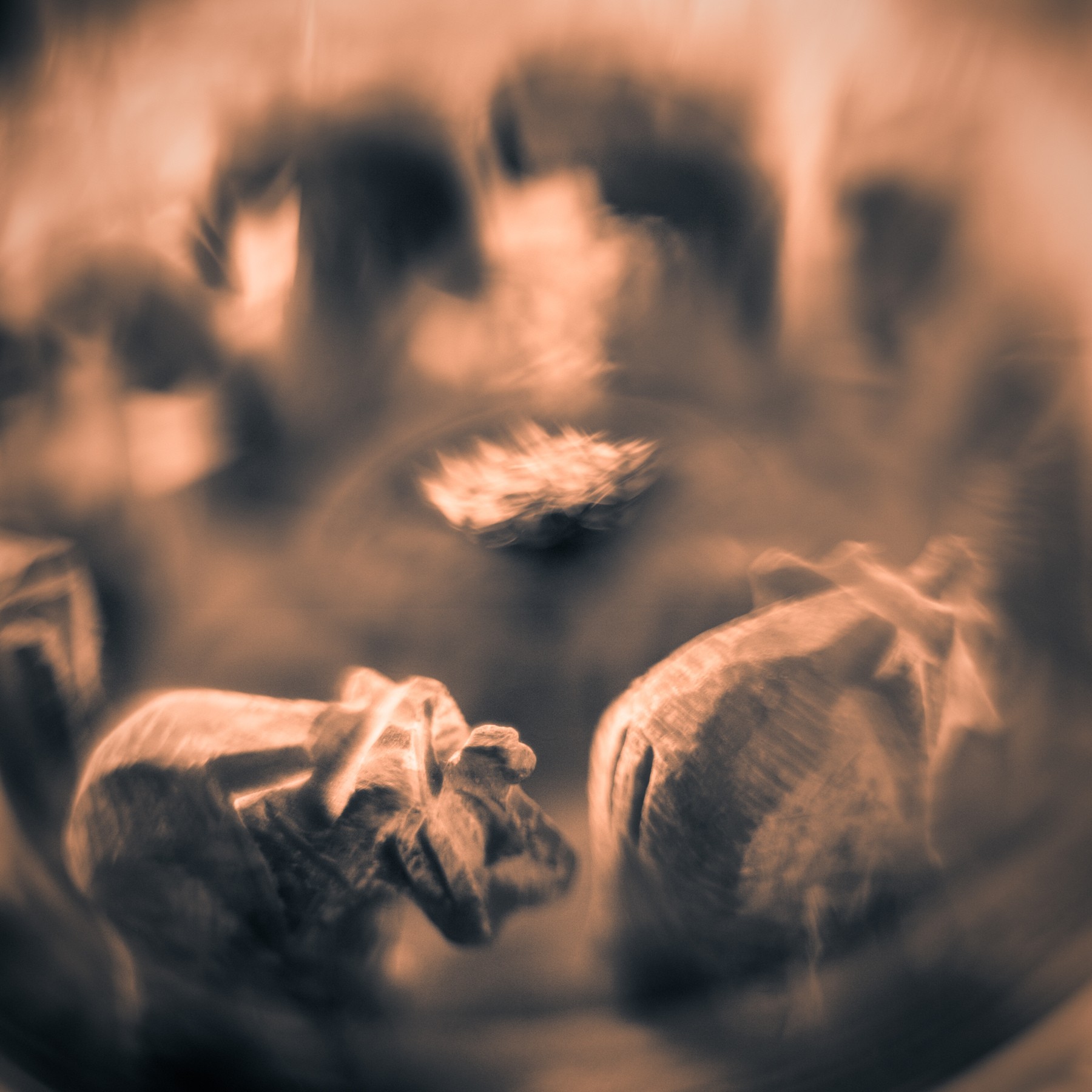 Close-up of coffee beans on a reflective surface with blurred background, warm tones, and soft focus.