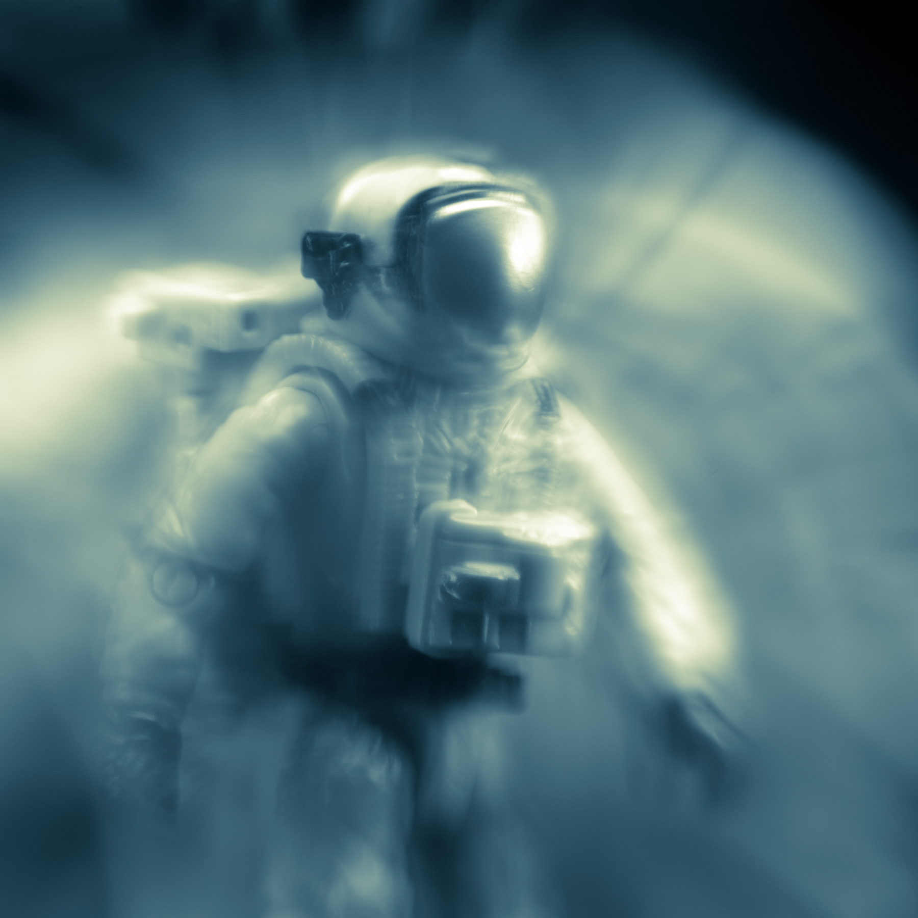 Astronaut in a spacesuit holding a device, with a blurred background and a glowing light effect.