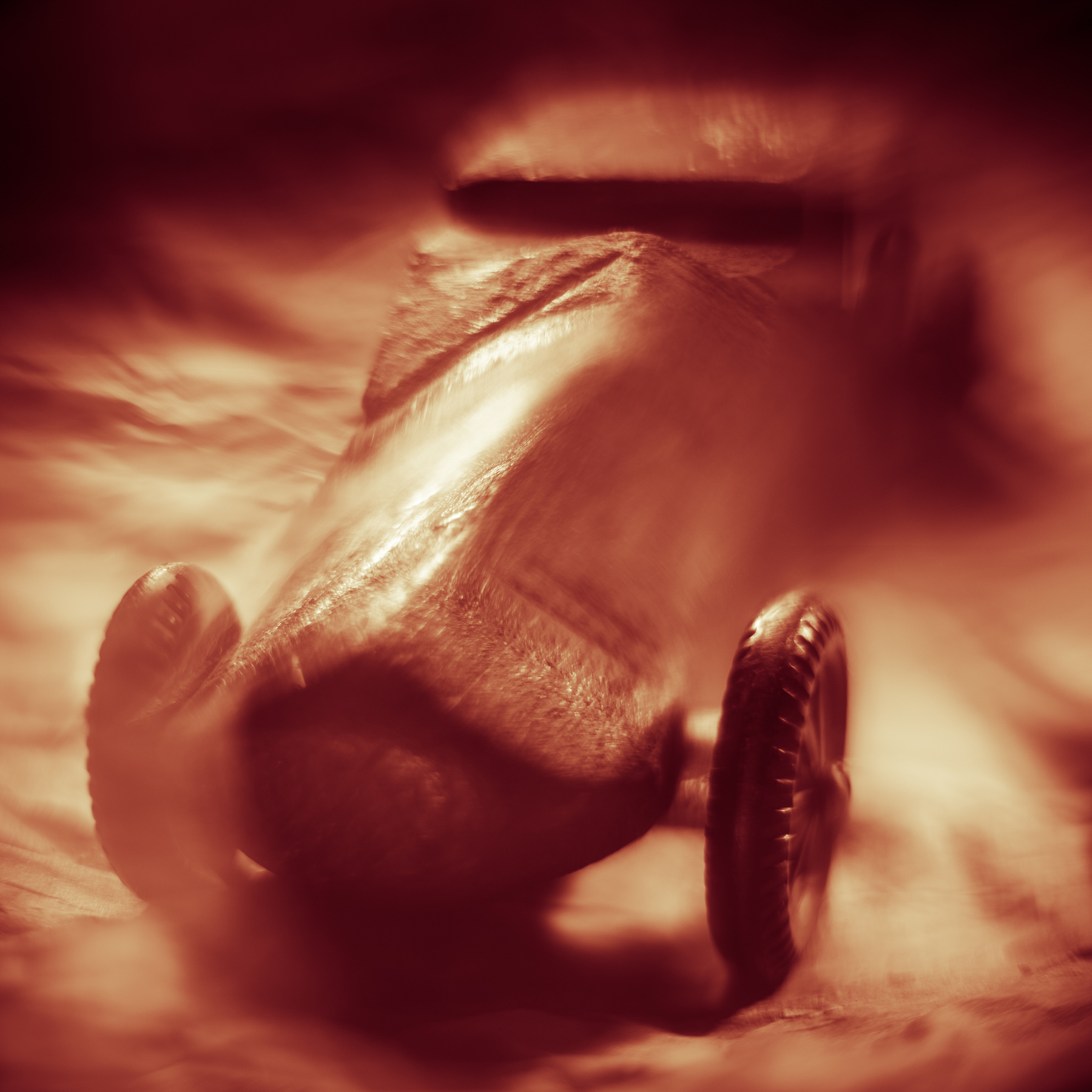 A close-up of a vintage pocket watch with a chain, lying on a surface with a blurred background.