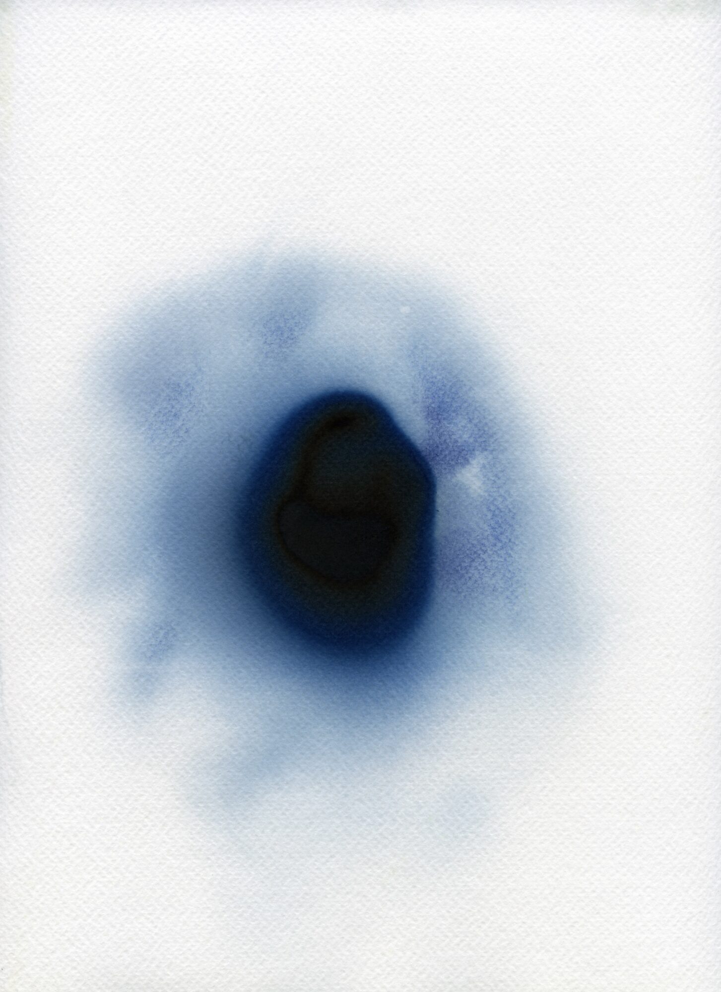 Dark central spot surrounded by blue and white diffuse pattern, on a white background.