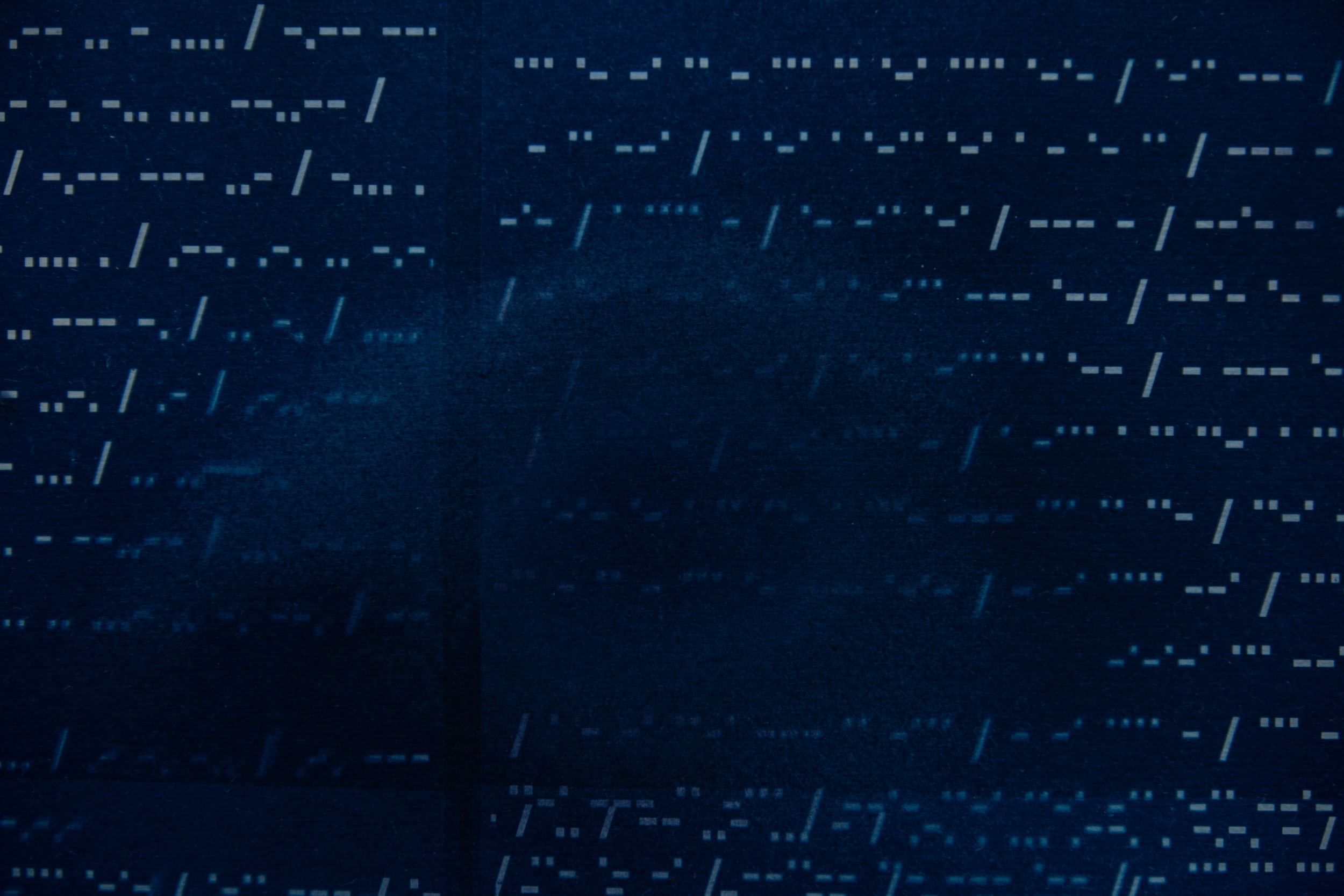 Dark background with white, scattered, horizontal lines and dots, resembling digital or computer code patterns.