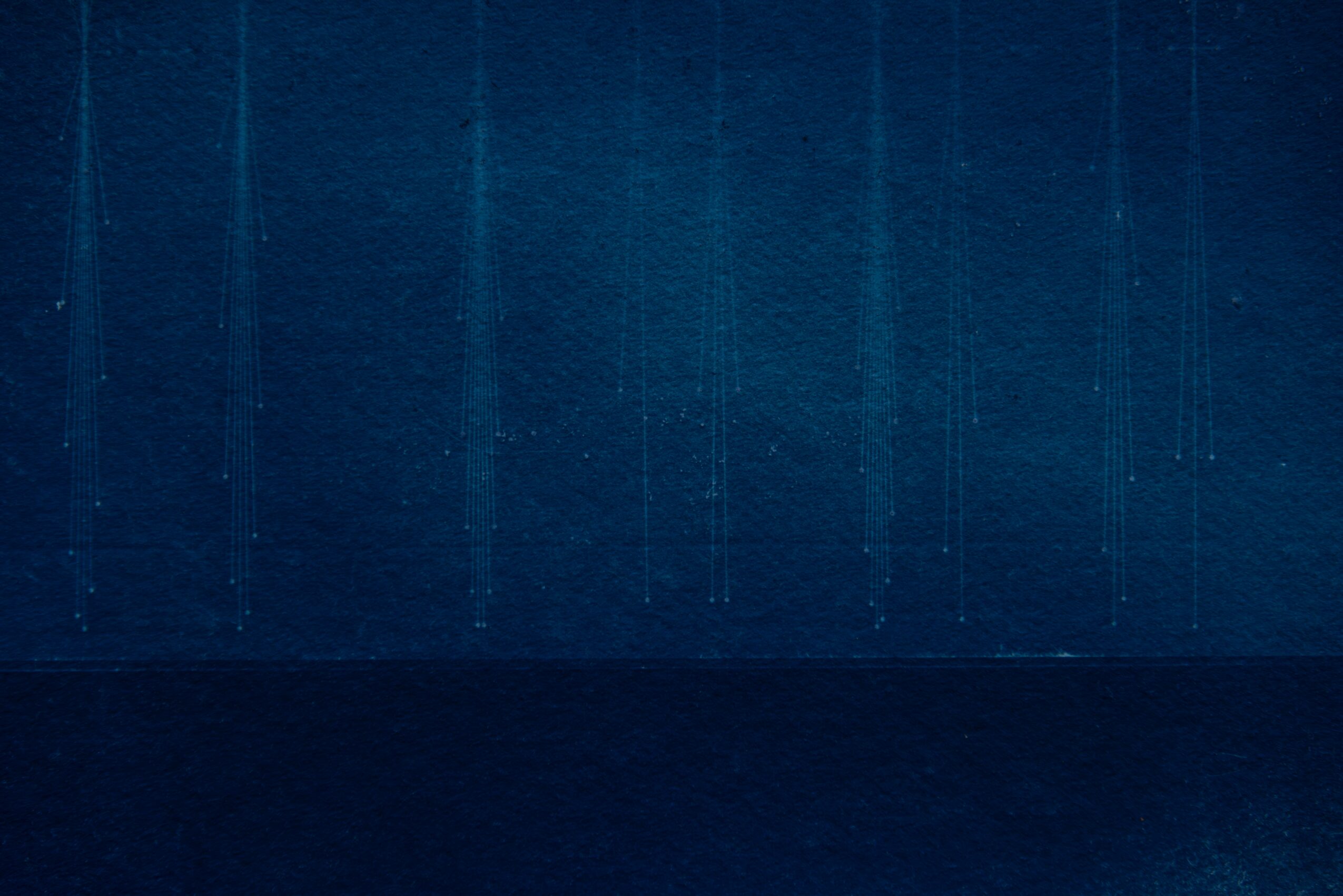 Close-up of a textured blue surface with vertical lines, divided by a darker horizontal band.