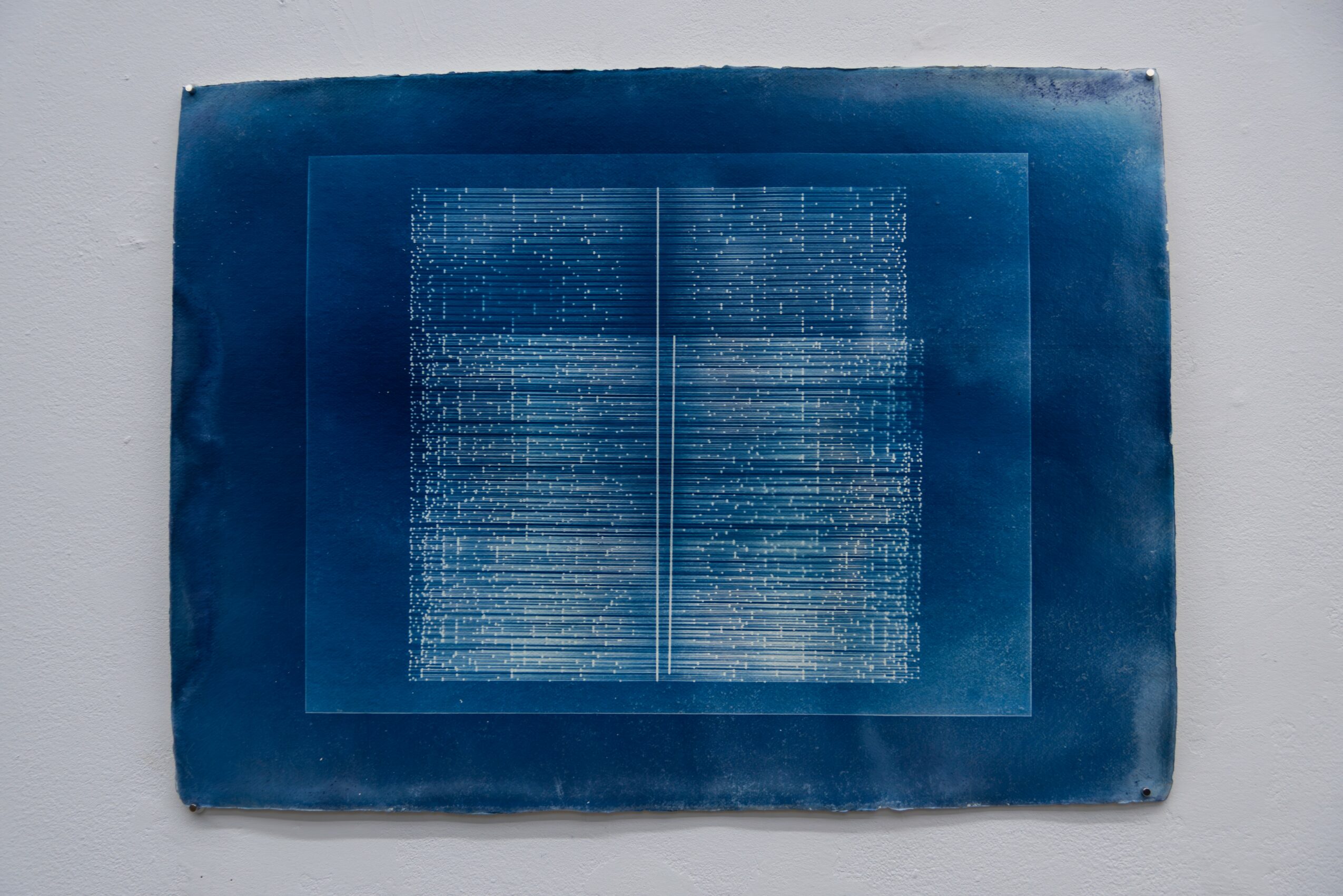 Blue book with text on open pages, placed on a white surface, viewed from the side.