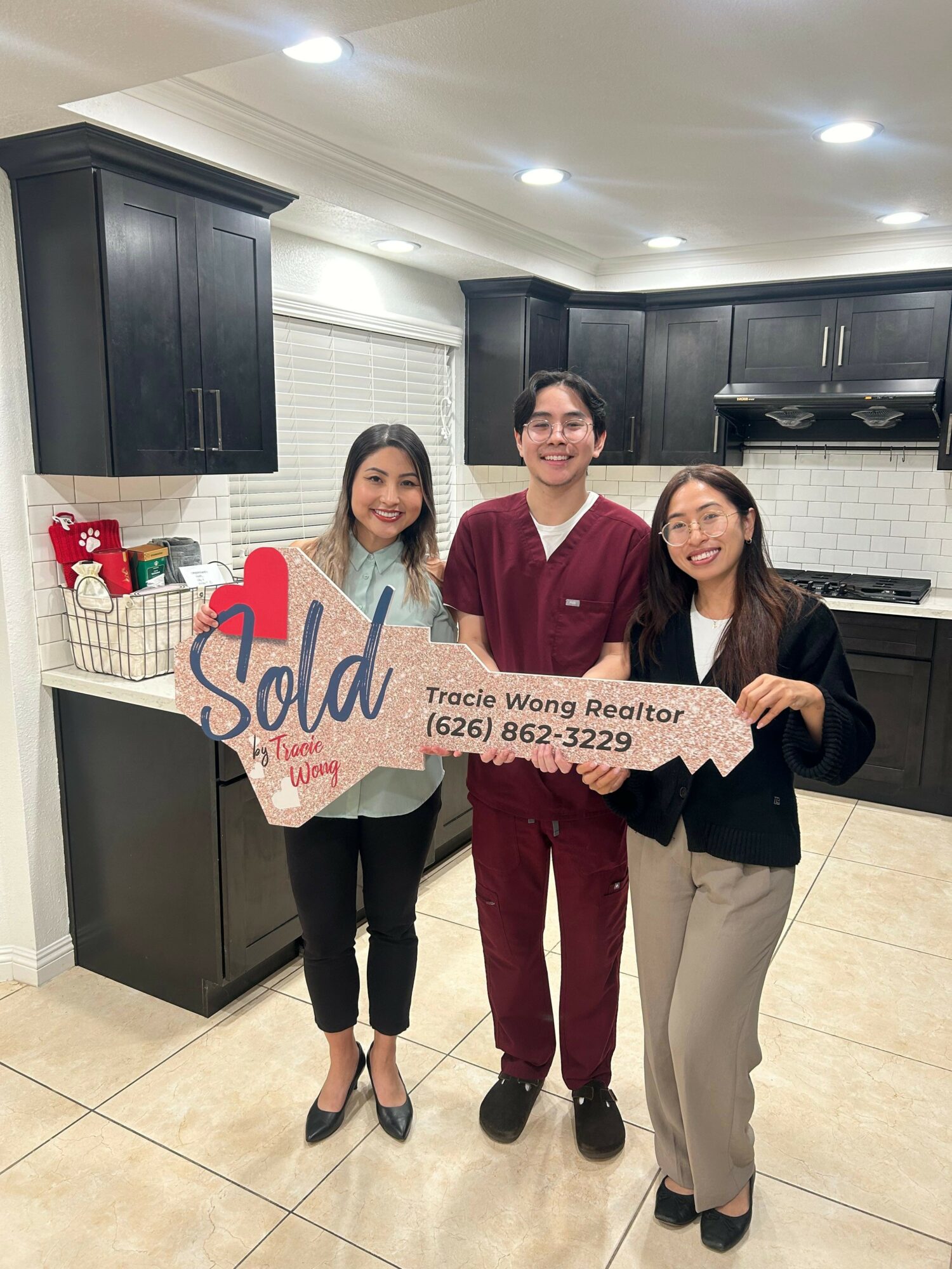 Two women and one girl holding a sign that says
