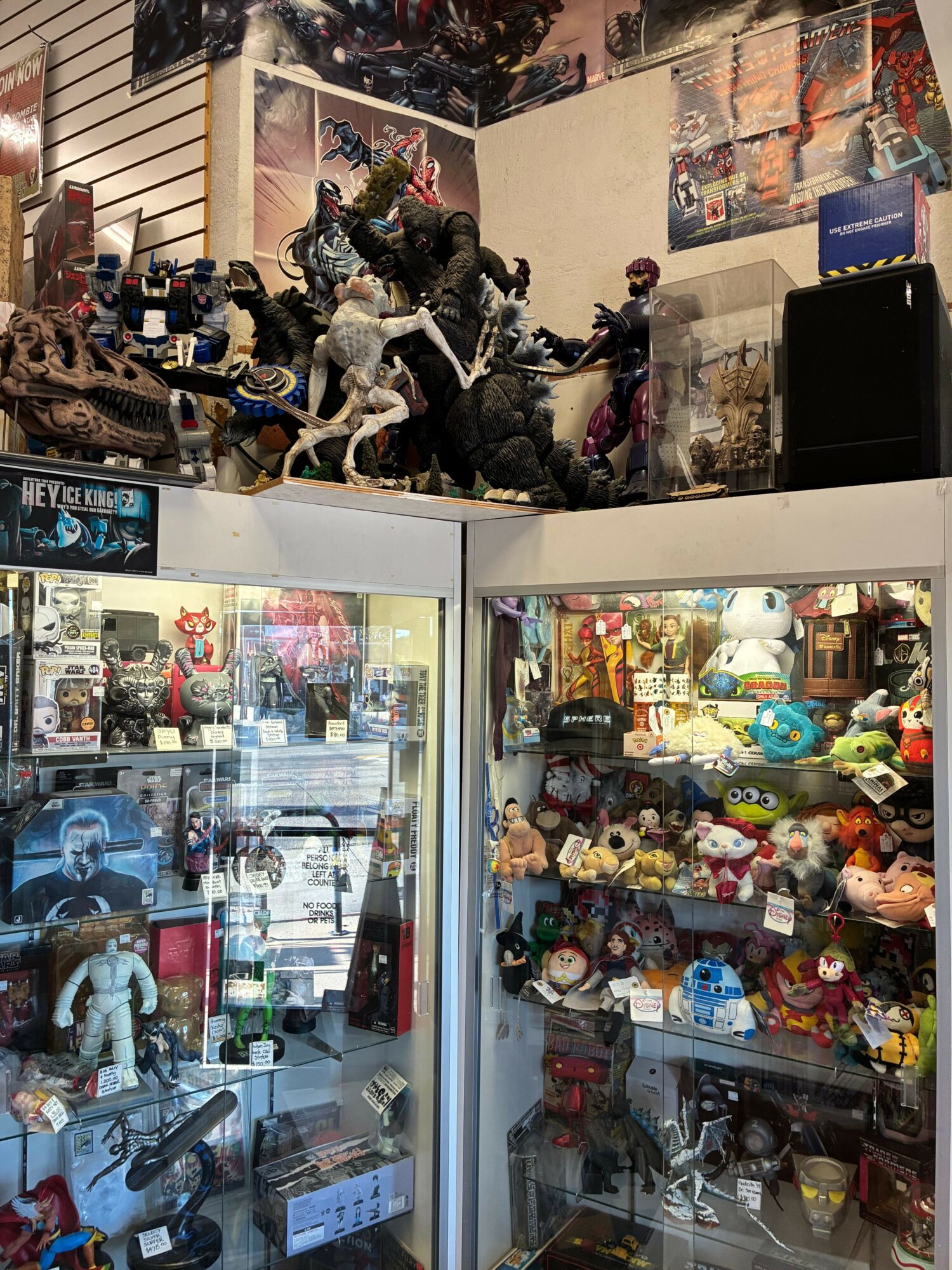 Display case filled with plush toys and collectibles, with a separate glass case showing various items inside, in a store.