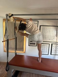 Person cleaning a floor with a mop in a room with framed pictures on the wall.
