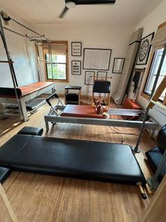 Room with exercise equipment, including a treadmill, weight bench, and framed pictures on the wall, viewed from the side.