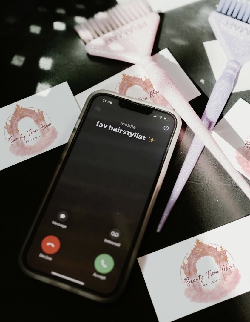 Smartphone with a call screen displaying 'fav hairstylist' on a table with hair dye swatches and notes.
