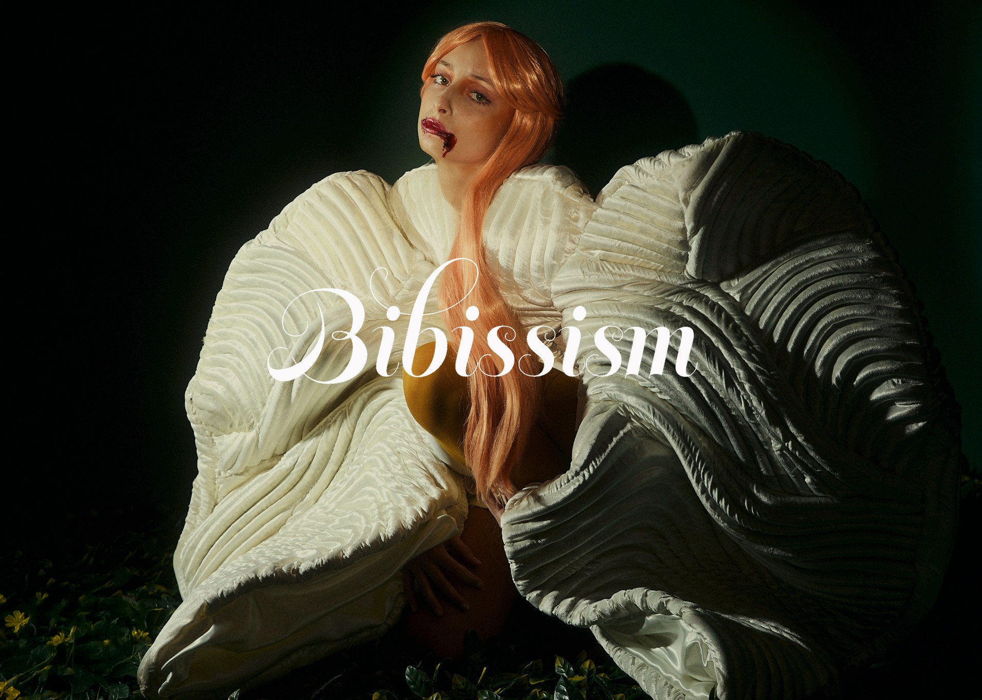 Woman with long red hair wearing a white sweater, sitting on the ground with dark background, text 'Bibissism' overlayed.