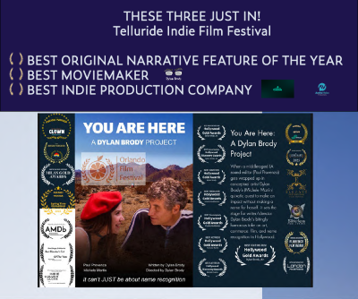Film festival award screen with text, logos, and a photo of two people, one wearing a red hat, in the center.