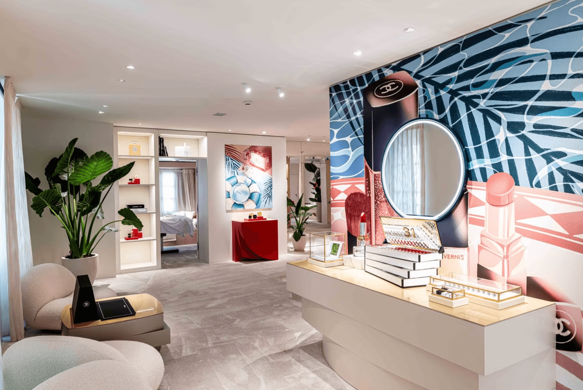 Living room with large plants, a white sofa, and a colorful mural wall with a mirror and decorative items.