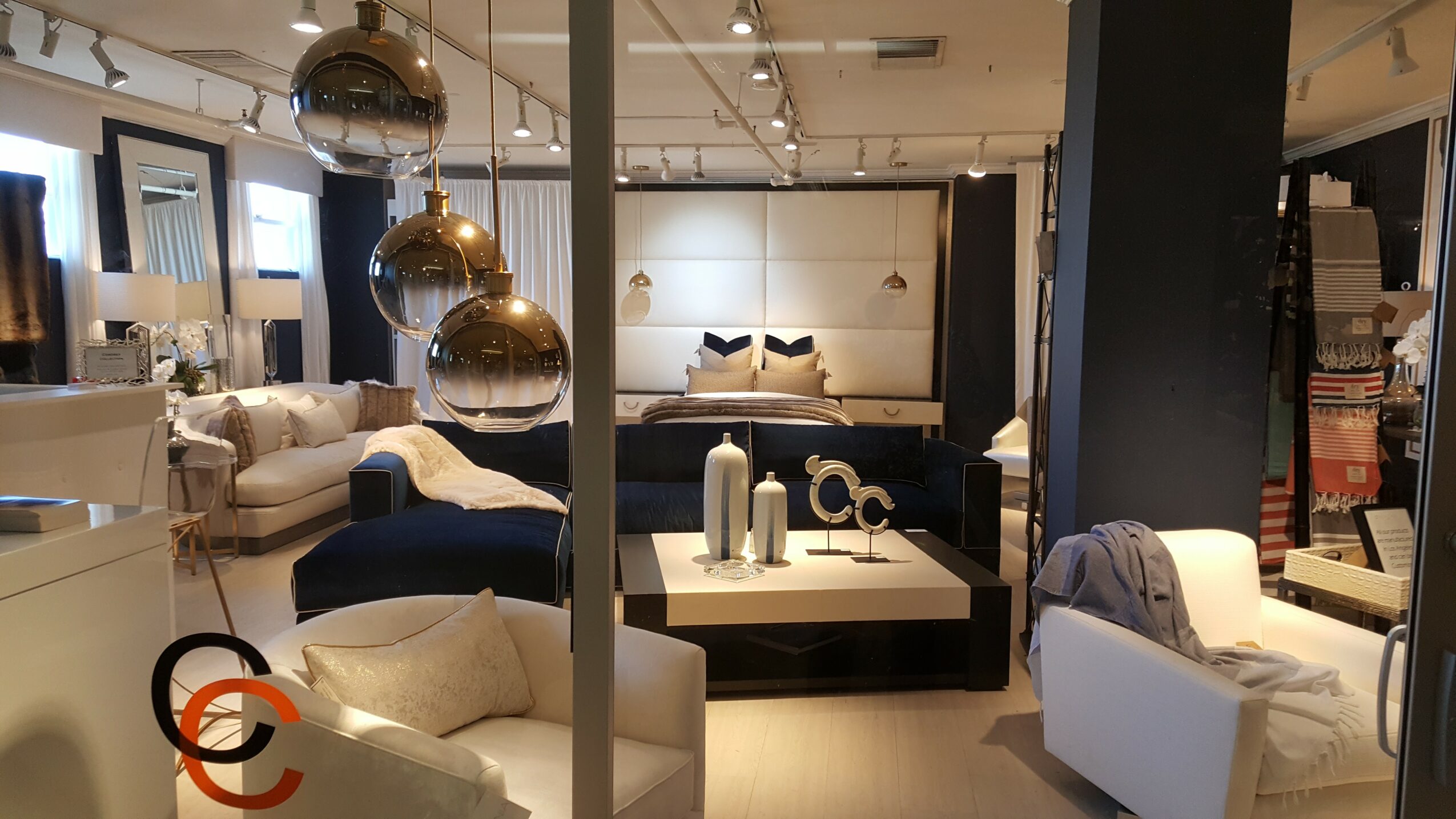 Modern living room with sofas, armchairs, and decorative items in a well-lit space.