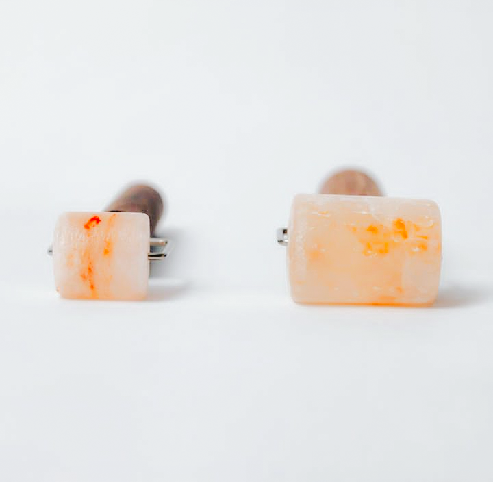 Two rectangular objects with rounded edges and orange markings, placed on a white surface, with a plain white background.