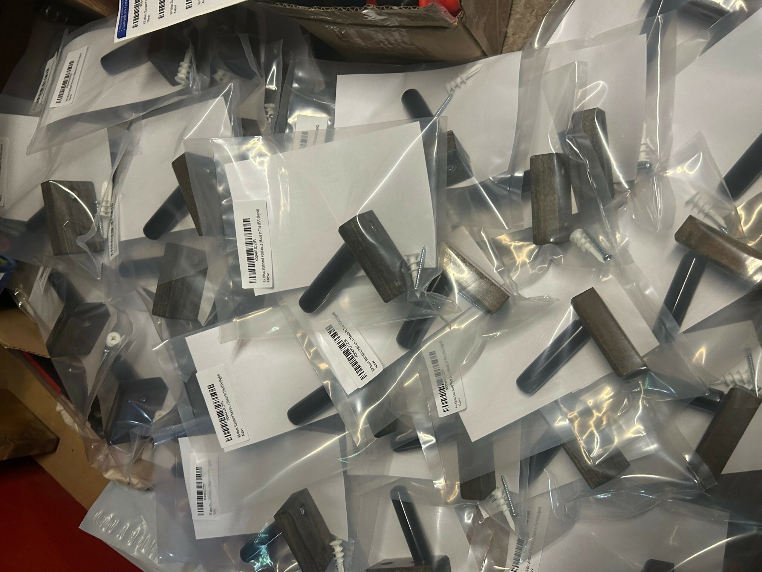 Multiple small black objects in clear plastic bags on a surface, with some labels visible.